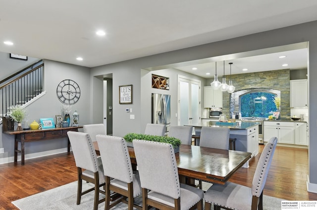 dining space featuring recessed lighting, light wood-type flooring, and stairs