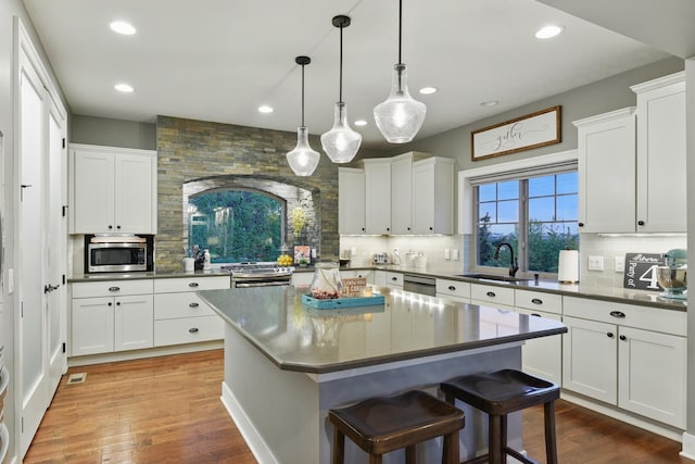 kitchen with a sink, appliances with stainless steel finishes, tasteful backsplash, and recessed lighting