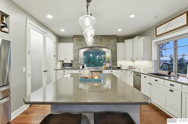 kitchen with a sink, a kitchen breakfast bar, tasteful backsplash, and stainless steel appliances