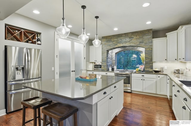 kitchen with recessed lighting, appliances with stainless steel finishes, decorative backsplash, and dark wood finished floors