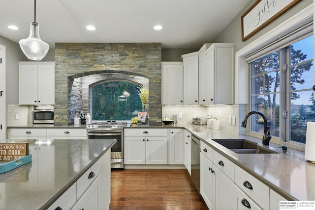kitchen featuring a sink, appliances with stainless steel finishes, backsplash, and white cabinetry