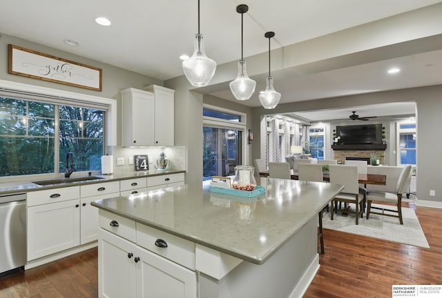 kitchen with a sink, dark wood finished floors, dishwasher, and tasteful backsplash