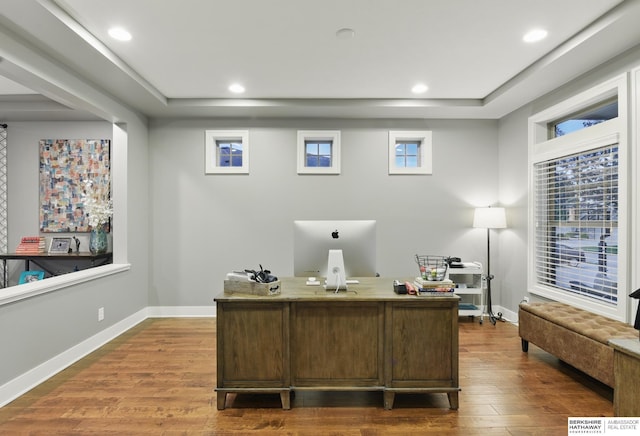 office area featuring recessed lighting, baseboards, wood finished floors, and a tray ceiling