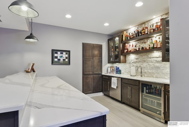 bar with a sink, beverage cooler, wet bar, decorative backsplash, and stainless steel dishwasher