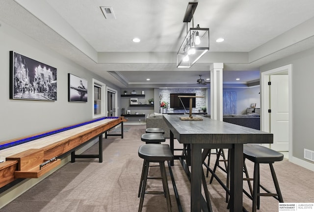 playroom with a raised ceiling, carpet floors, a ceiling fan, baseboards, and visible vents