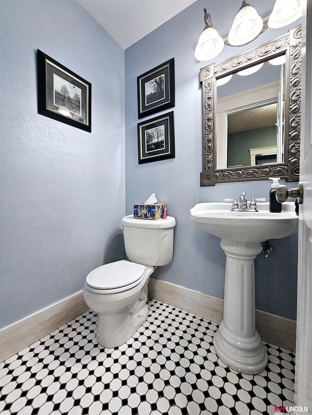 bathroom featuring baseboards and toilet