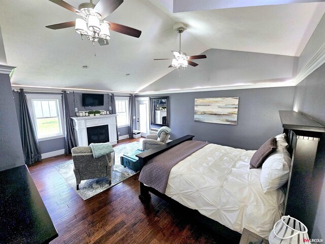 bedroom featuring lofted ceiling, ceiling fan, baseboards, a glass covered fireplace, and wood finished floors