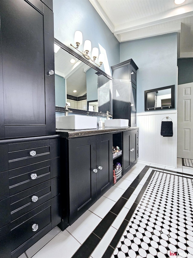 bathroom featuring tile patterned floors, vanity, and a wainscoted wall