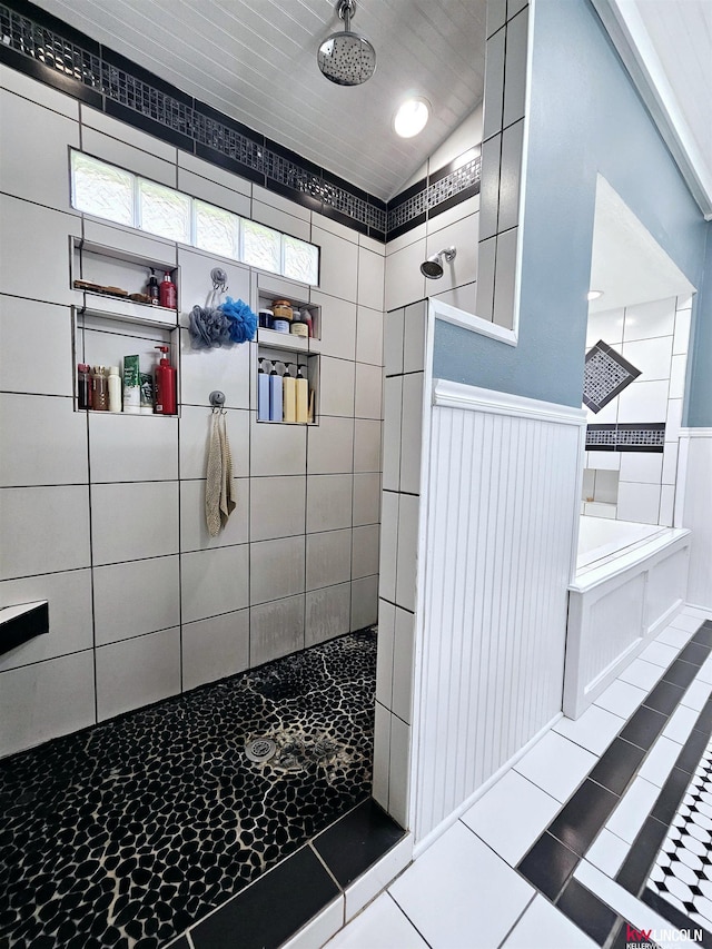 bathroom featuring a walk in shower, tile patterned flooring, and vaulted ceiling