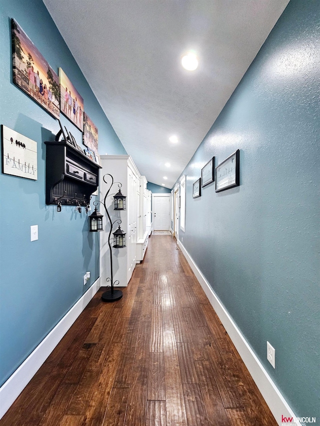 hall featuring vaulted ceiling, recessed lighting, dark wood finished floors, and baseboards