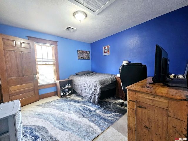 bedroom featuring carpet flooring, a textured ceiling, and visible vents