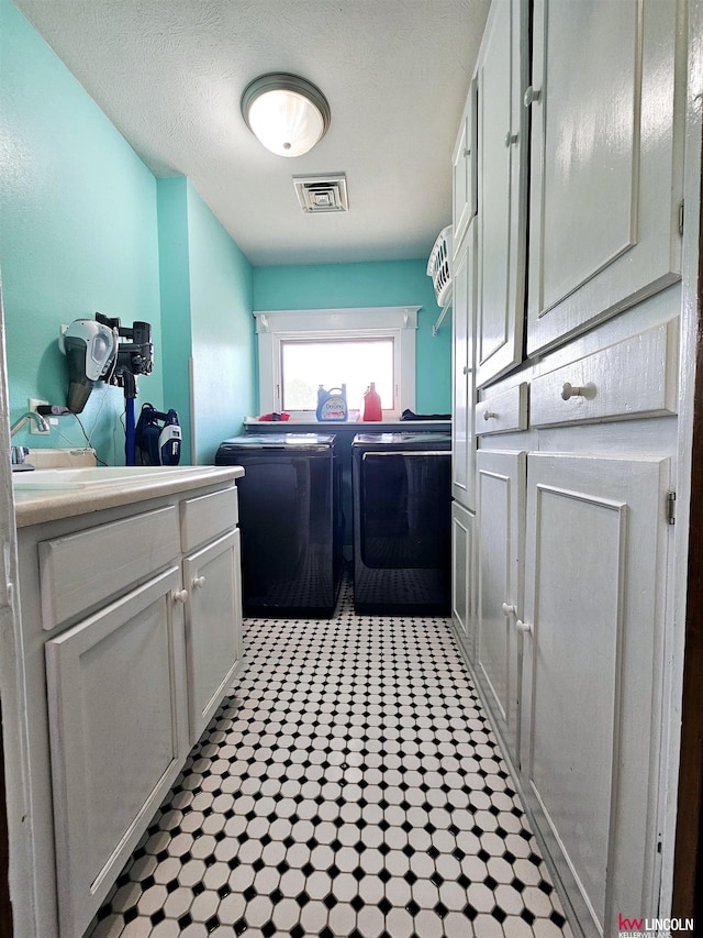 laundry area with cabinet space, washer and clothes dryer, tile patterned floors, and visible vents