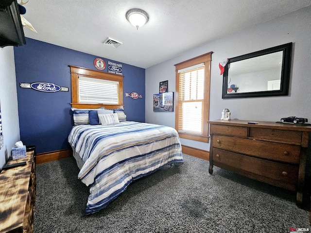 carpeted bedroom featuring a textured ceiling, visible vents, and baseboards