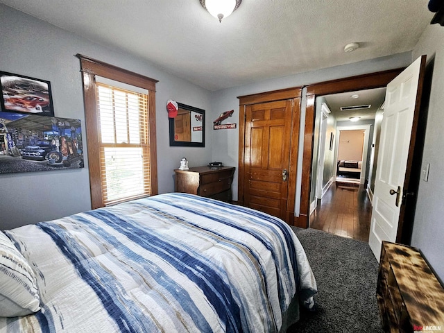 bedroom featuring wood finished floors and visible vents