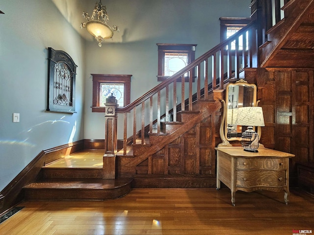 stairway with hardwood / wood-style flooring and a high ceiling