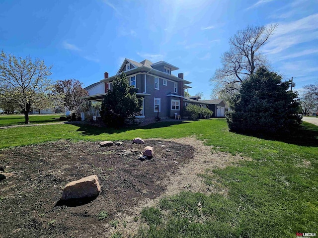 view of side of home featuring a chimney and a yard