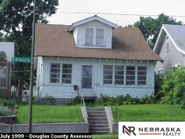 cape cod house with stairway and a front yard