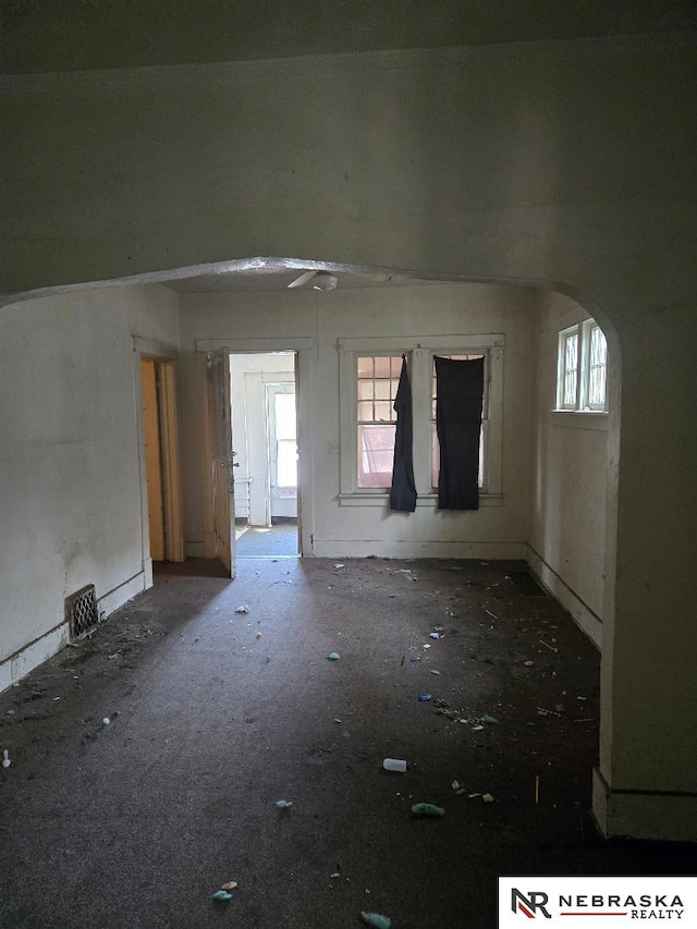 unfurnished room featuring arched walkways