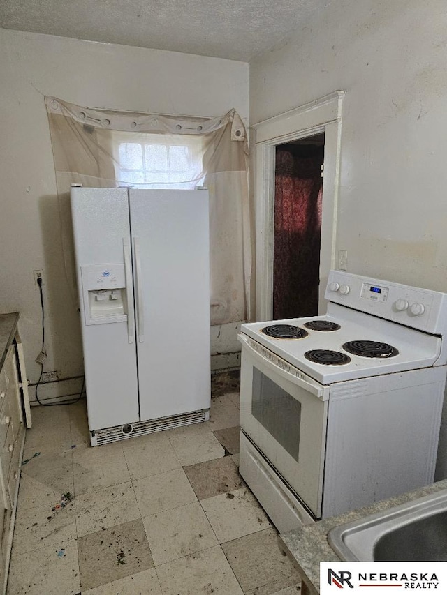 kitchen featuring light floors, white appliances, and a sink
