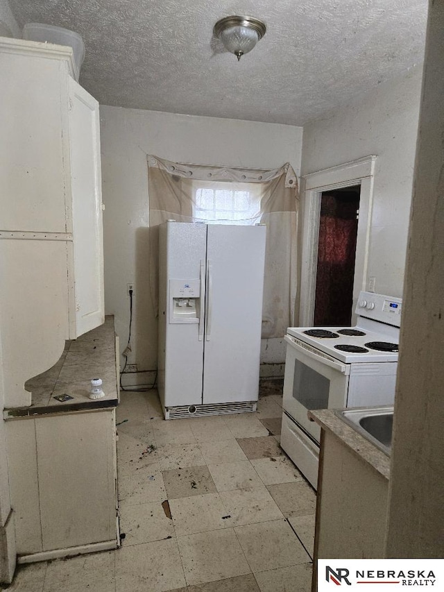 kitchen with white cabinetry, light floors, white appliances, and a sink