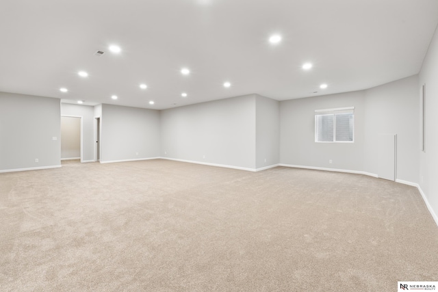 basement featuring baseboards, recessed lighting, and light colored carpet