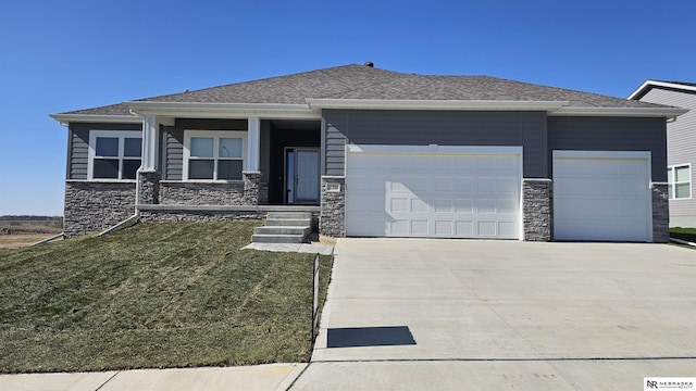 view of front of home with a front lawn, driveway, stone siding, and a garage