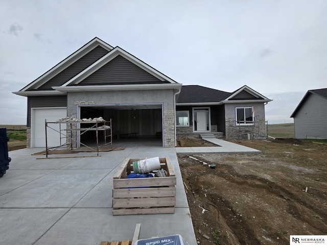 view of front of property featuring concrete driveway, stone siding, and an attached garage