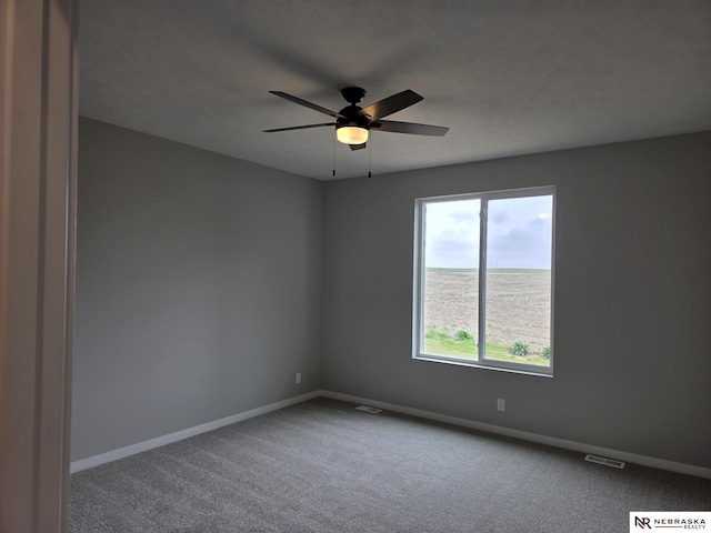 spare room with visible vents, ceiling fan, a water view, and baseboards