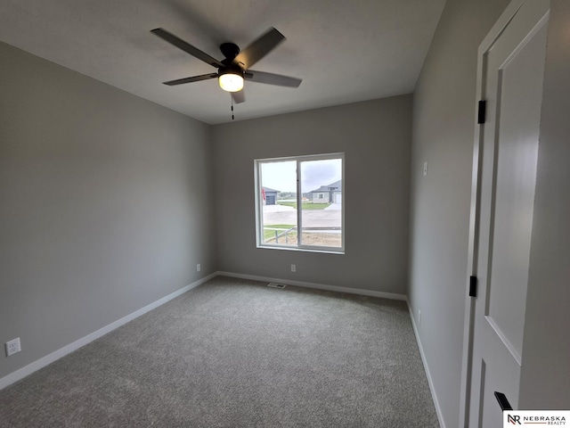unfurnished room with a ceiling fan, carpet, and baseboards