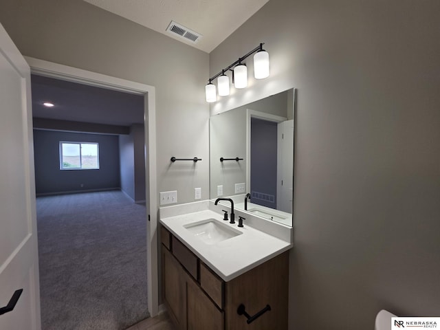bathroom featuring visible vents, vanity, and baseboards