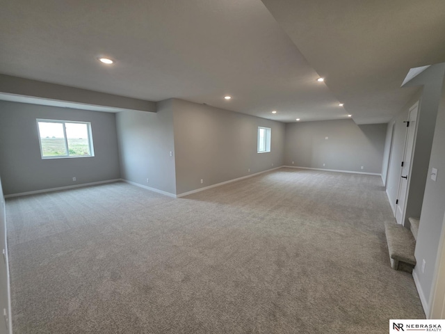 below grade area with baseboards, recessed lighting, carpet flooring, and plenty of natural light