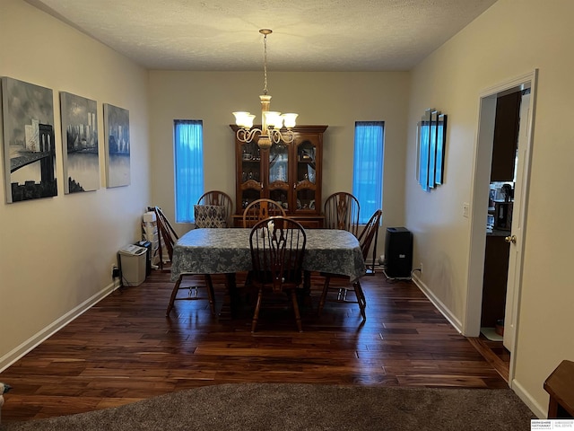 dining space featuring dark wood finished floors, baseboards, and an inviting chandelier