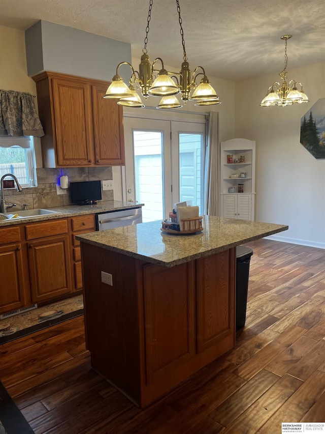 kitchen with a center island, dark wood-style floors, an inviting chandelier, and a sink