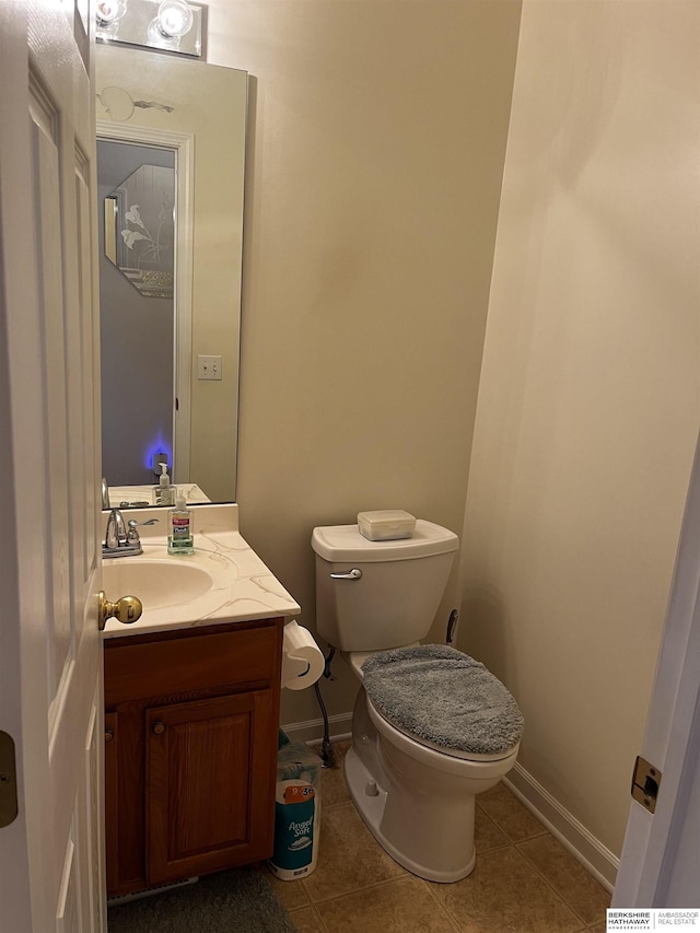bathroom with tile patterned floors, baseboards, toilet, and vanity