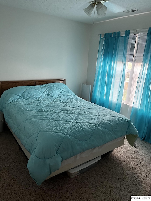 bedroom featuring visible vents, ceiling fan, and carpet floors