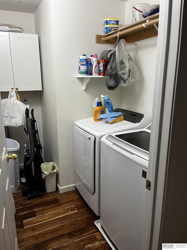 clothes washing area with dark wood-style flooring, baseboards, cabinet space, and washing machine and dryer
