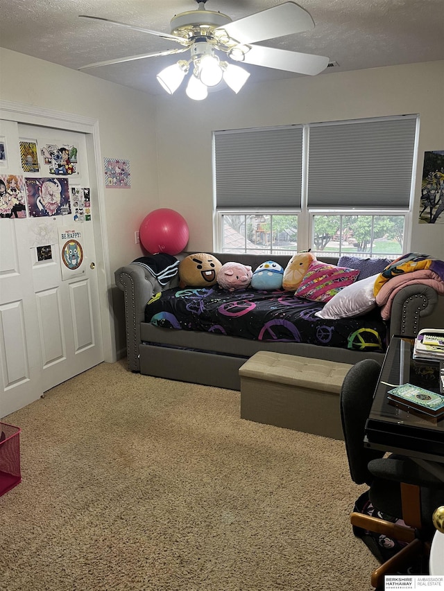 carpeted bedroom with a textured ceiling and ceiling fan