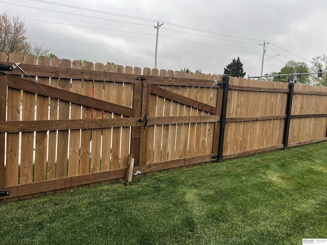 view of gate featuring fence and a yard