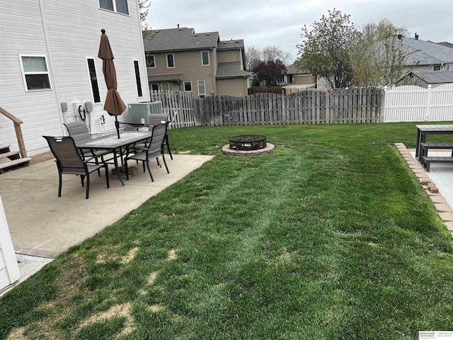 view of yard featuring a residential view, a patio, fence, and an outdoor fire pit