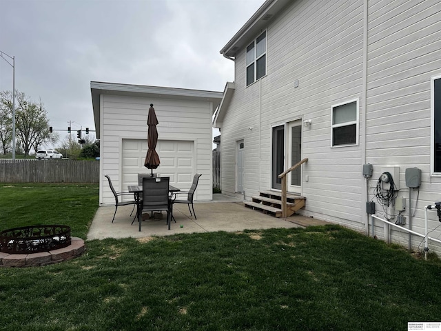 rear view of house featuring a yard, a fire pit, fence, a patio, and entry steps