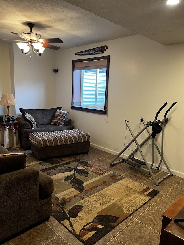 living area featuring a ceiling fan and baseboards