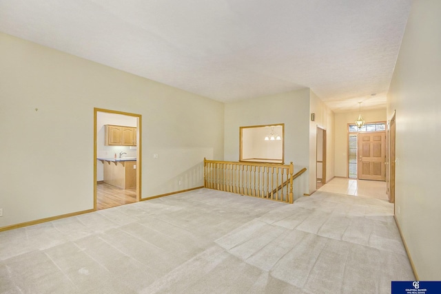 spare room with light colored carpet and baseboards