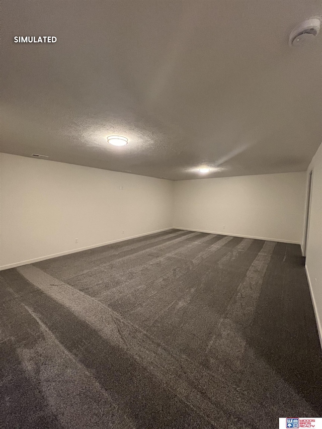 finished below grade area featuring dark colored carpet and baseboards