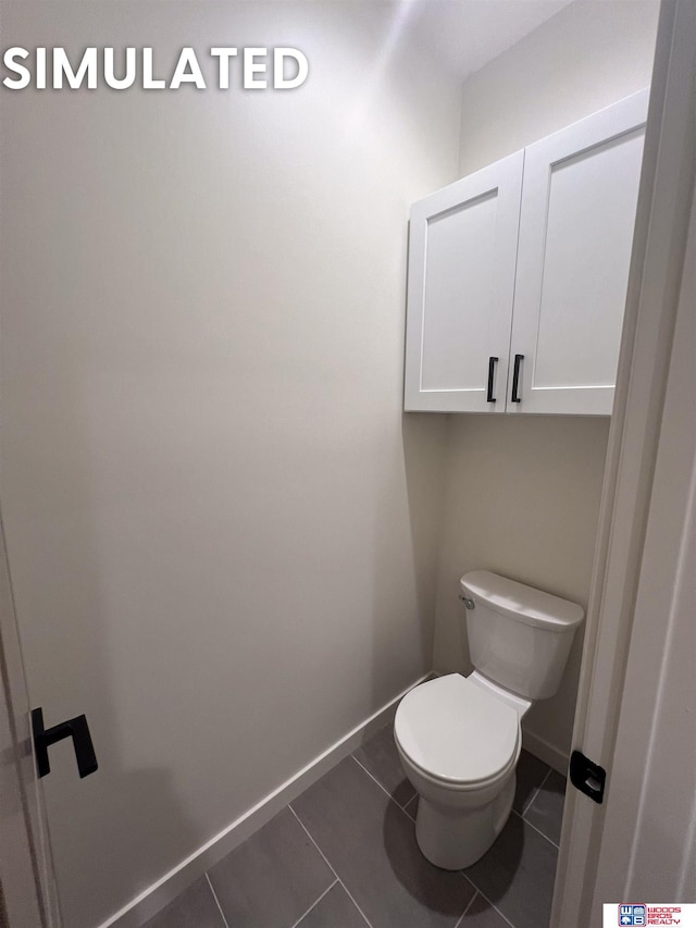 bathroom featuring toilet, tile patterned flooring, and baseboards