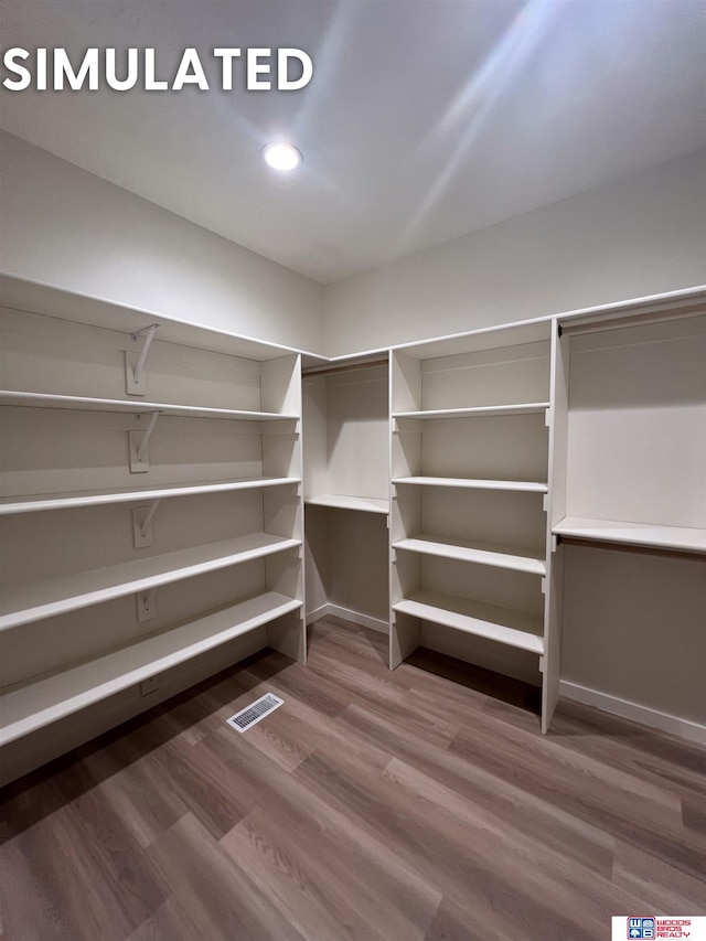 walk in closet featuring visible vents and wood finished floors