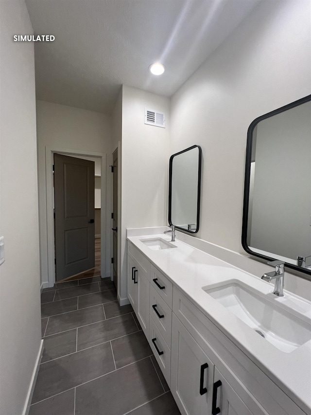 bathroom with tile patterned flooring, a sink, baseboards, and visible vents