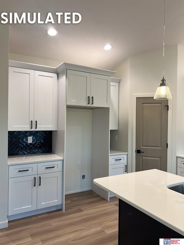 kitchen with recessed lighting, light wood-style flooring, decorative backsplash, light countertops, and pendant lighting