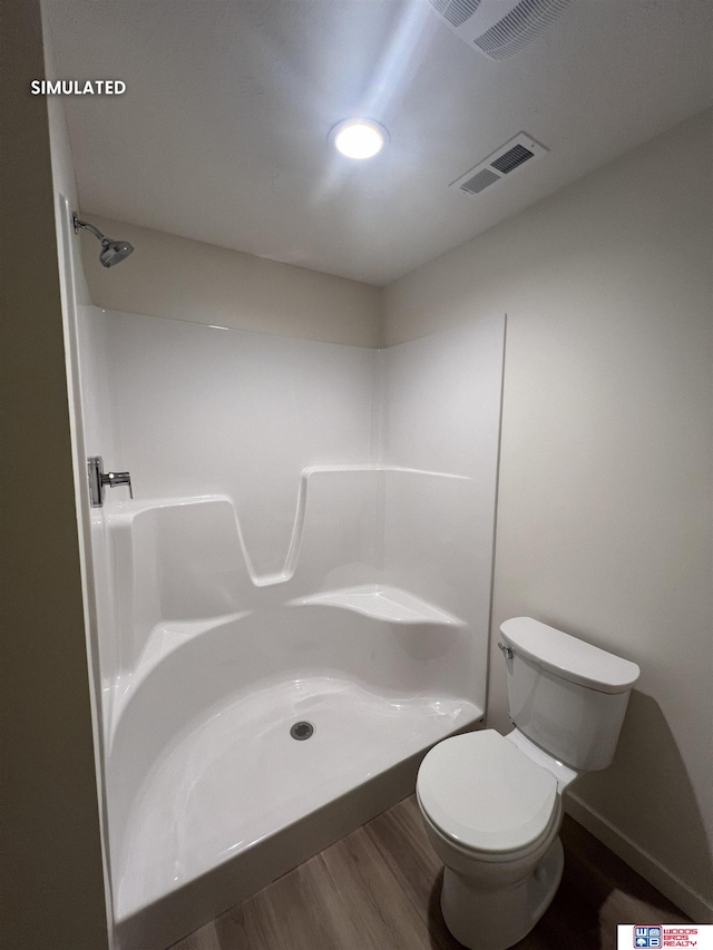 bathroom featuring visible vents, wood finished floors, walk in shower, and toilet