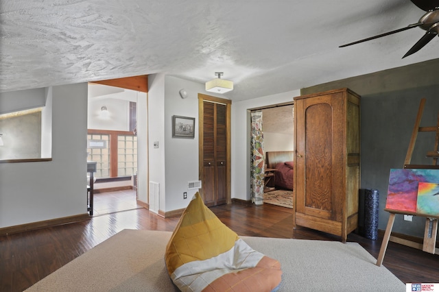 bedroom with a ceiling fan, baseboards, visible vents, and wood finished floors