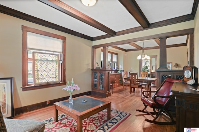 living room with an inviting chandelier, ornamental molding, light wood-style floors, and beam ceiling